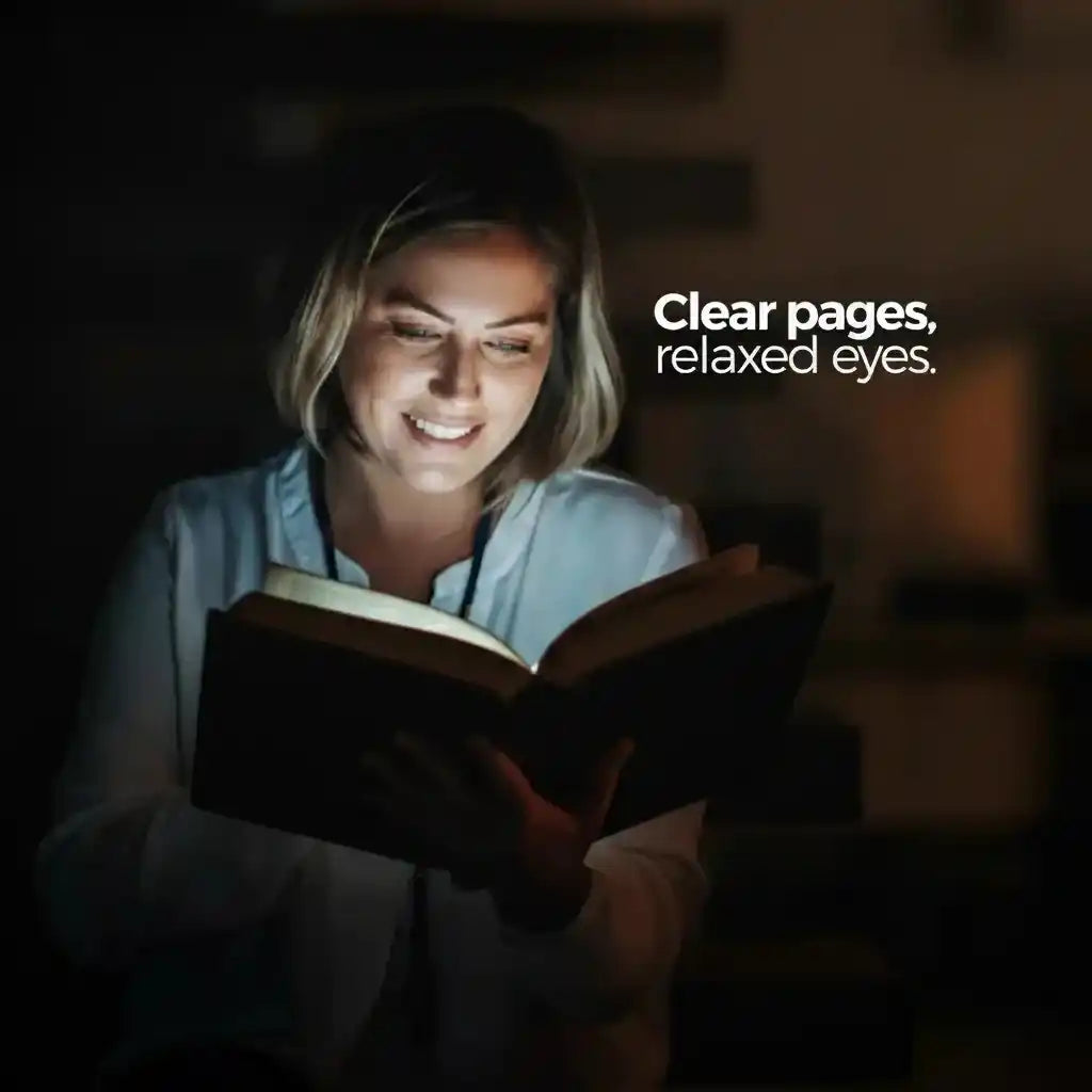 VisionGlow book light — clear pages relaxed eyes — smiling young woman reading with bright even light on book in dark background